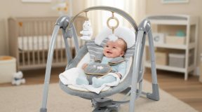 Happy newborn baby securely harnessed in plush seat of Ingenuity Swing ‘n Go Deluxe with toy bar overhead