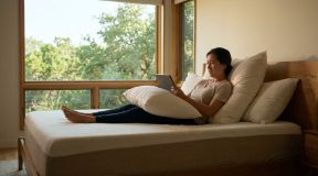 Person experiencing neck pain while lying in bed